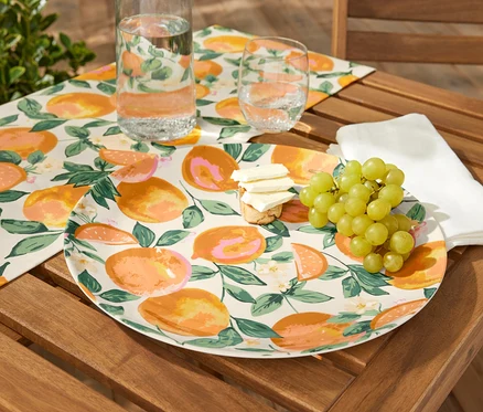 Servierteller mit Obst, Käse und Trauben auf einem Holztisch.