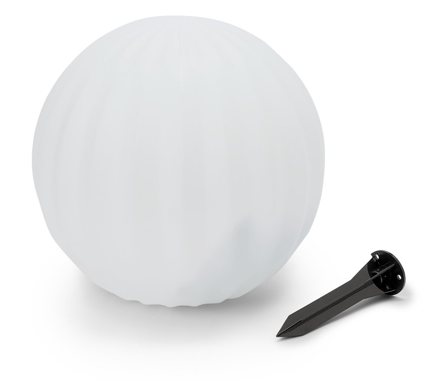 Eine weiße Kugel liegt neben einem schwarzen Erdspieß.