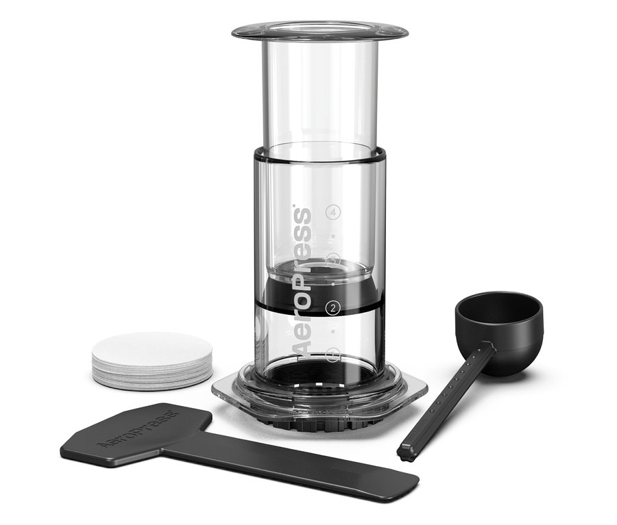 Aeropress Kaffeebereiter mit Zubehör auf weißem Hintergrund.
