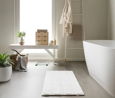 Badezimmer mit weißer Badewanne und weißer benuta Badematte »Ilka«, 50 x 80 cm.