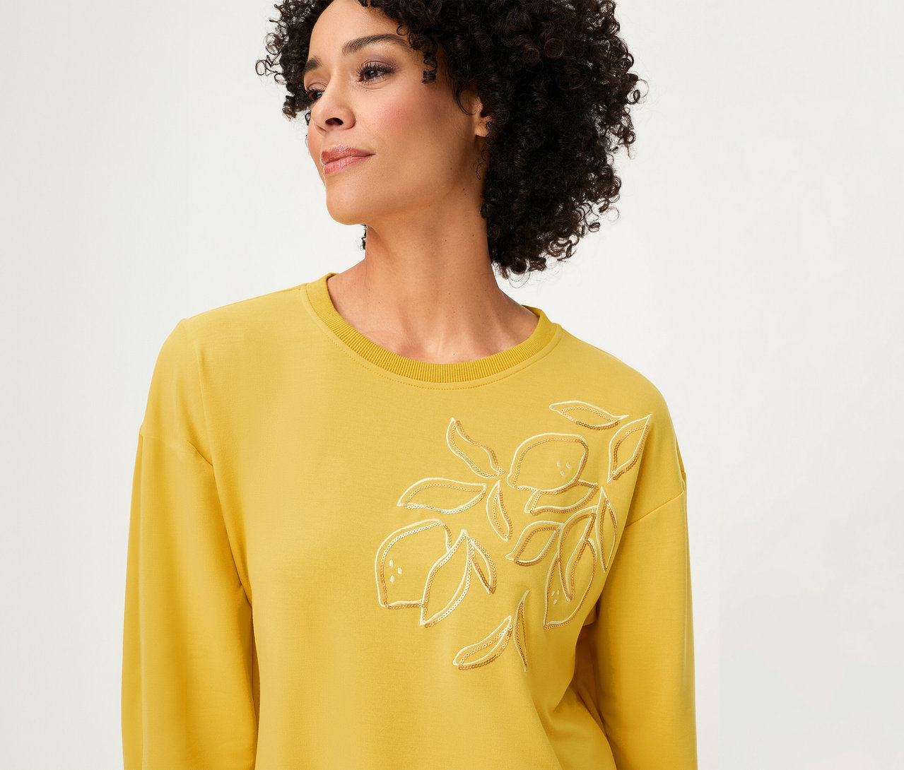 Frau trägt ein gelbes Olsen Sweatshirt Long Sleeves mit Zitronen-Applikation.