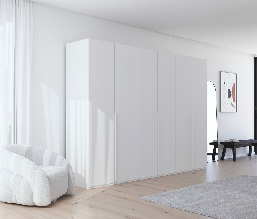 Ein großes, weißes, modernes Schlafzimmer mit einem weißen Sessel, einem großen weißen Kleiderschrank und einem grauen Teppich.