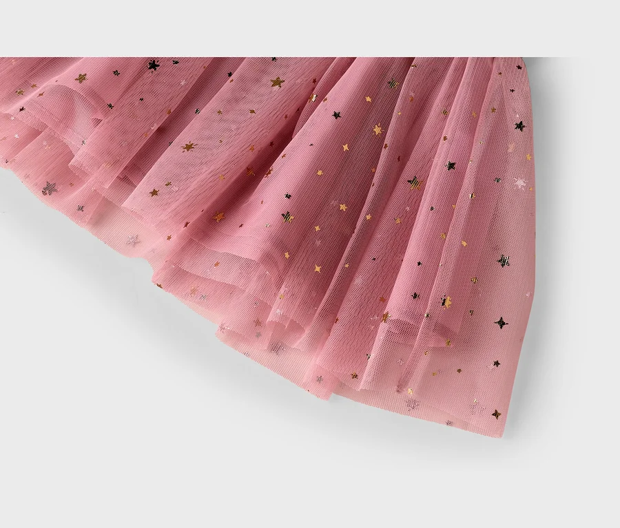 Nahaufnahme eines rosa Tüllstoffs mit goldenen Sternen, der Falten und Rüschen zeigt.