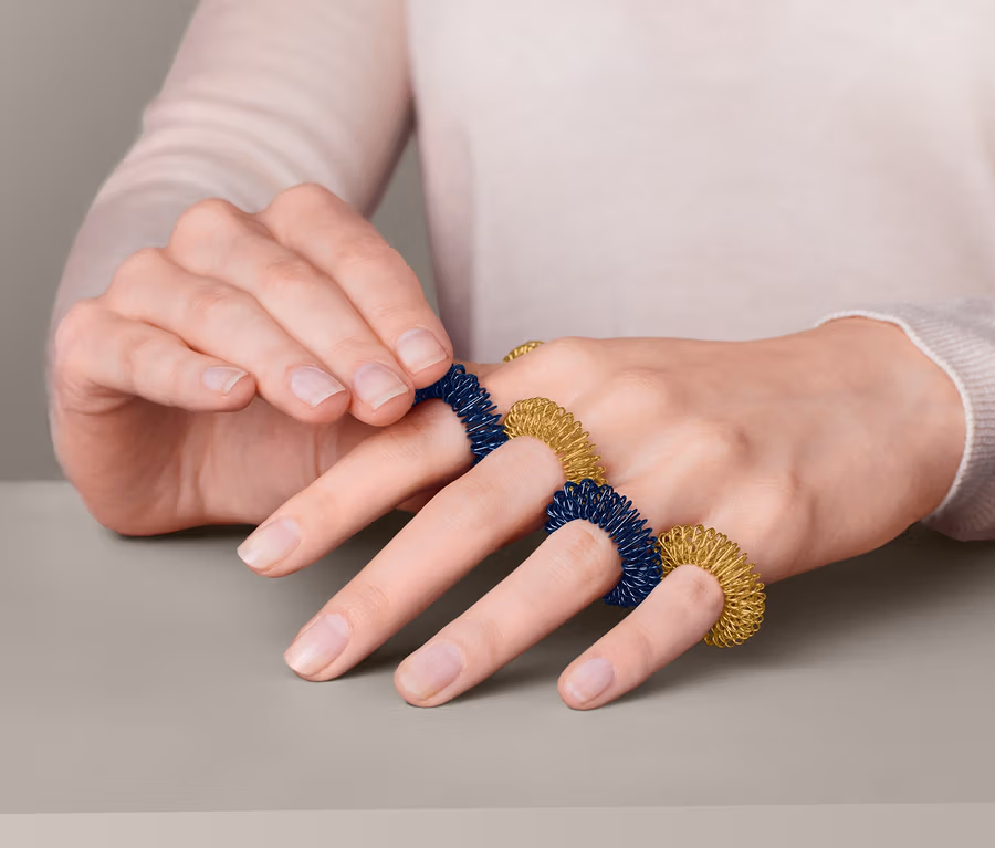 Eine Frau legt einen Fingermassagering an.