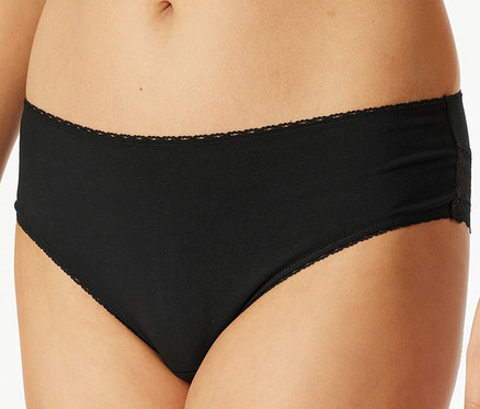 Detailaufnahme einer Frau, die schwarze Unterwäsche mit Spitze trägt.