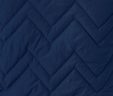 Detailaufnahme einer blauen Thermoweste mit Fischgrätenmuster.