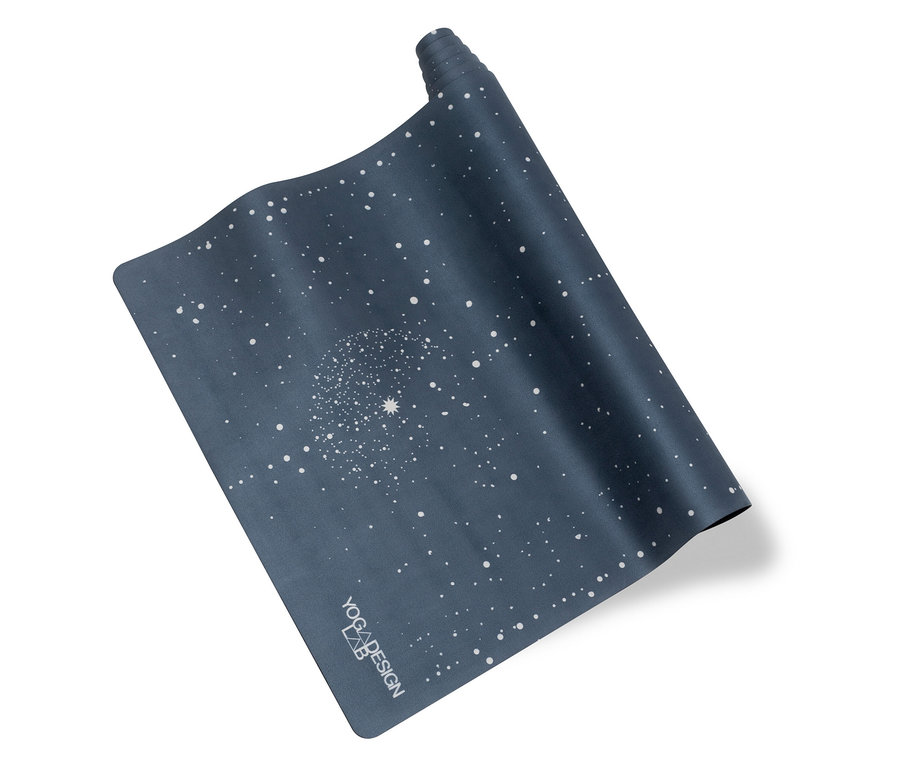 Eine teilweise aufgerollte, dunkelblaue Yogamatte mit weißem Punktmuster.