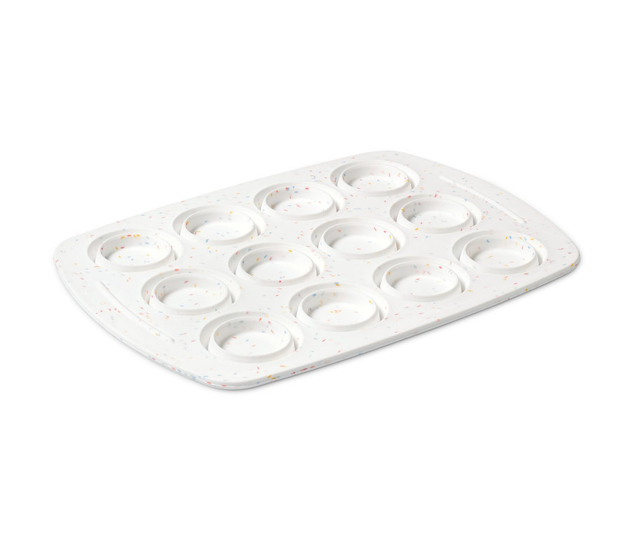 Weißes Muffinblech mit zwölf Mulden und bunten Sprenkeln.