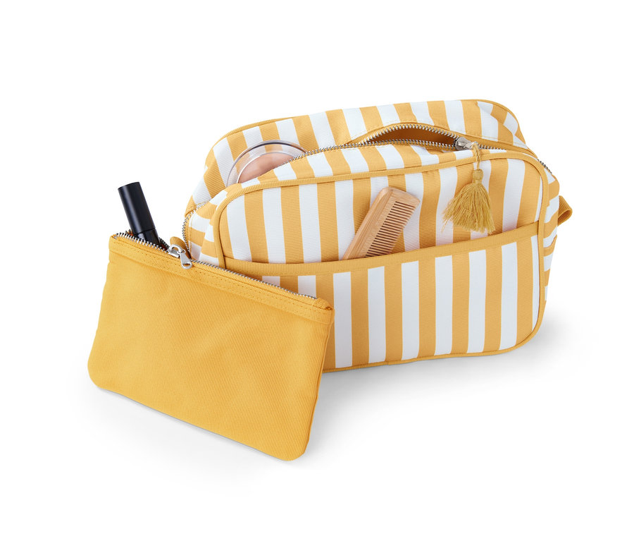 Eine Kulturtasche mit Kosmetiktasche mit gelben und weißen Streifen, darin ein Kamm und Puder.