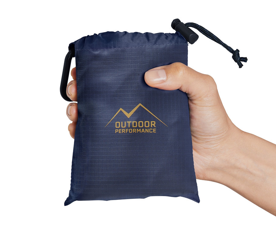 Eine Hand hält eine blaue Tasche mit einer Mini-Picknickdecke.