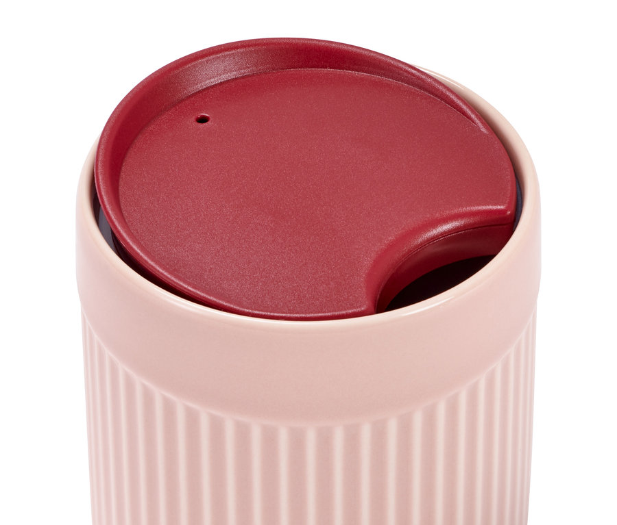 Nahaufnahme eines rosa Porzellanbechers mit Deckel.