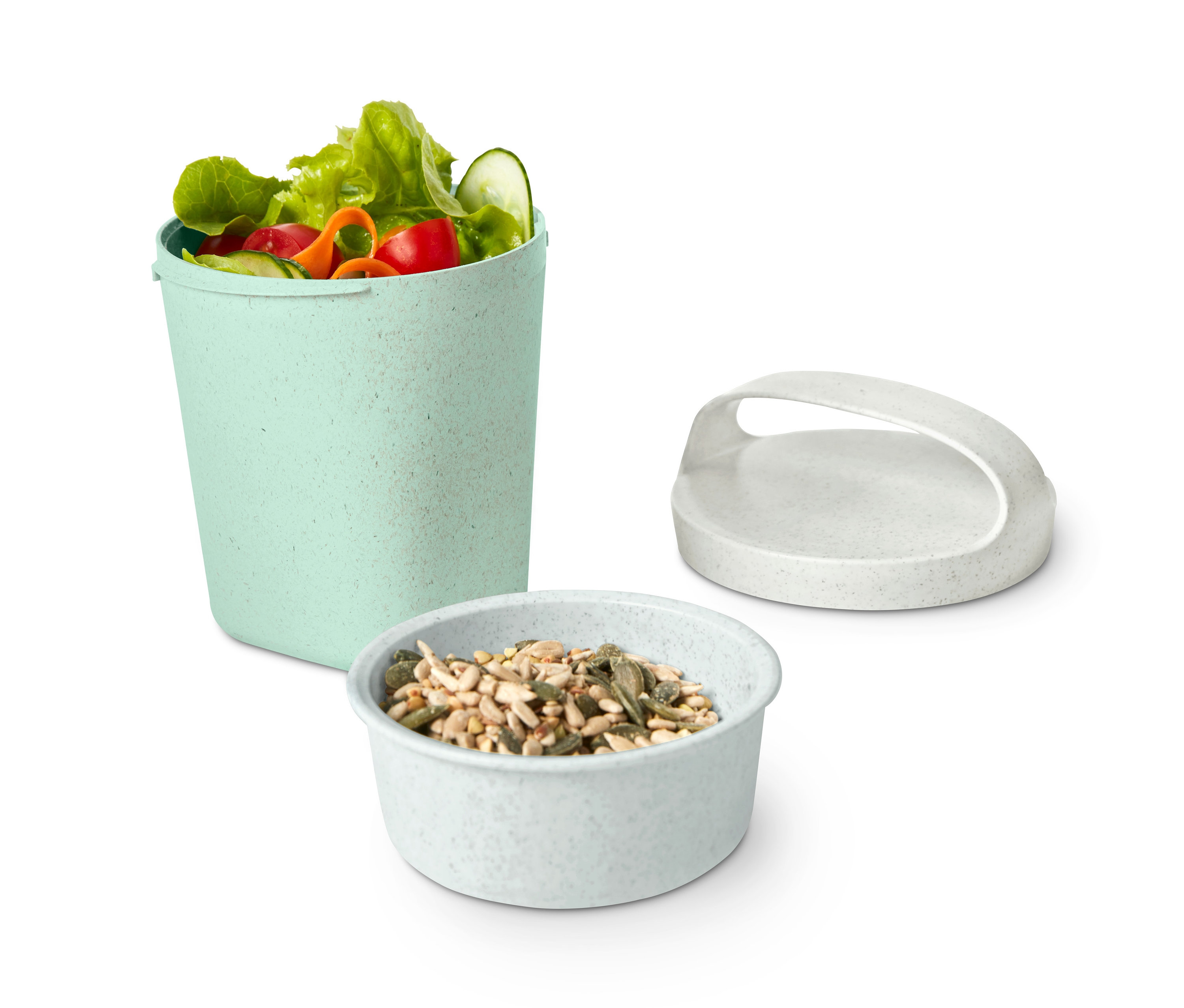 Salat im KOZIOL-Snackpot »Buddy« neben Samen und Deckel.