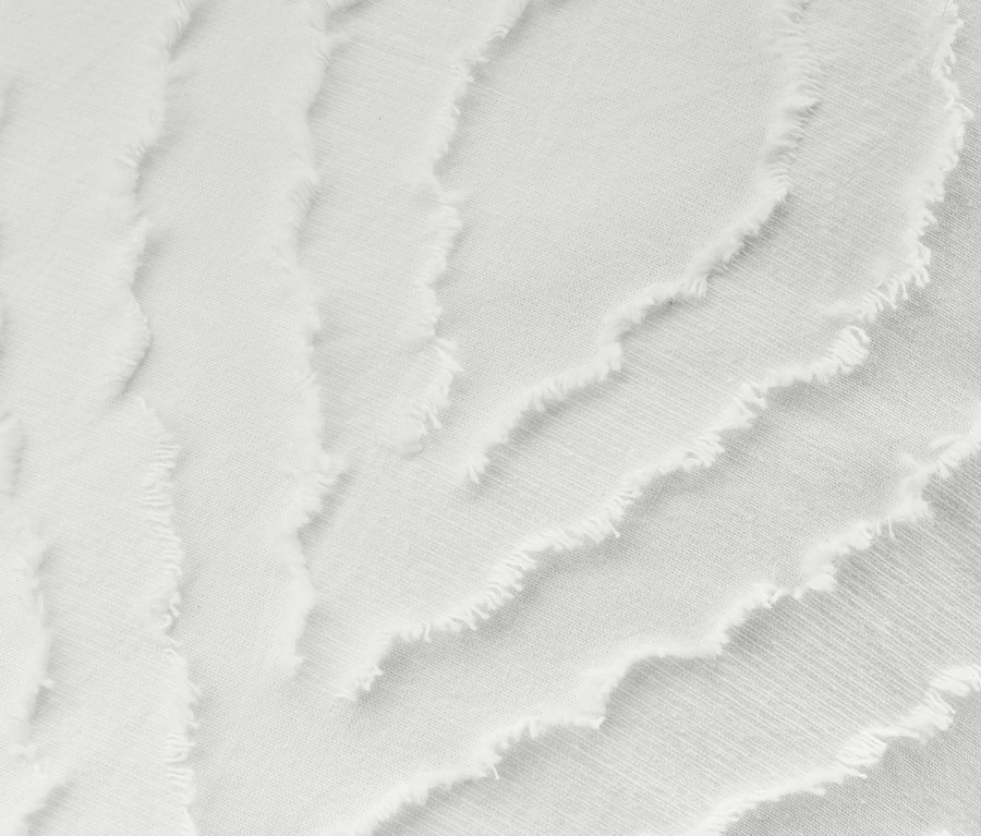 Detailansicht eines weißen Dekokissenbezugs mit Textur.
