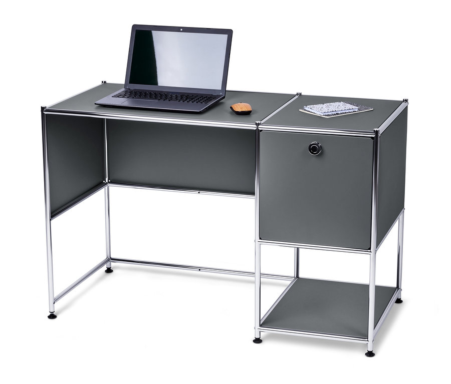 Auf einem grauen Metall Schreibtisch »CN3« mit Klapptür stehen ein Laptop und ein Notizbuch.