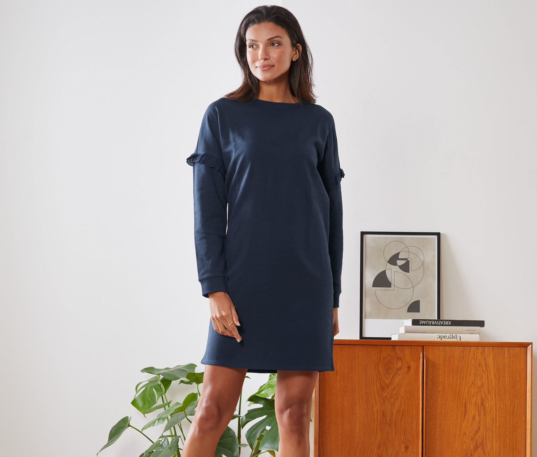 Frau posiert in einem Sweatkleid.