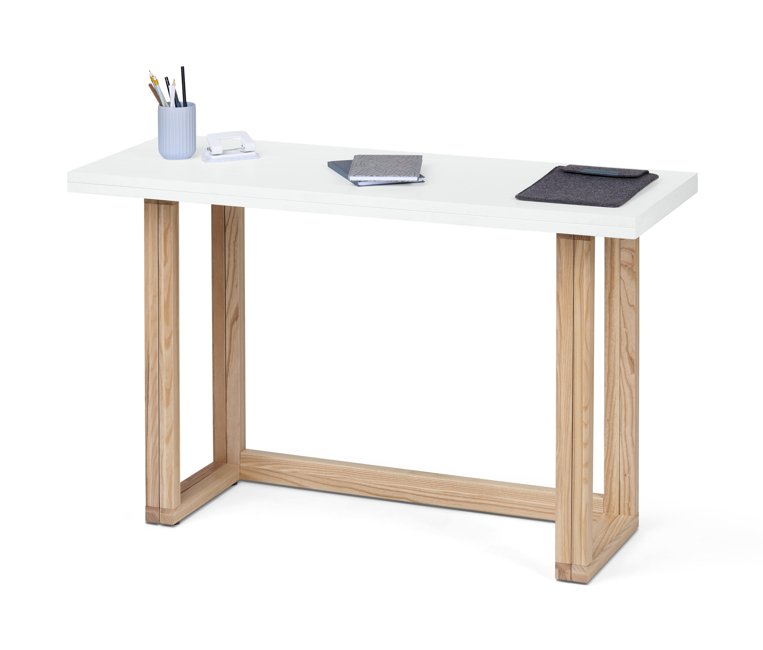 Ein weißer, wandelbarer Ess- und Arbeitstisch mit Holzbeinen. Auf dem Tisch liegen Schreibutensilien, ein Hefter, Notizbücher und eine Dokumentenhülle.