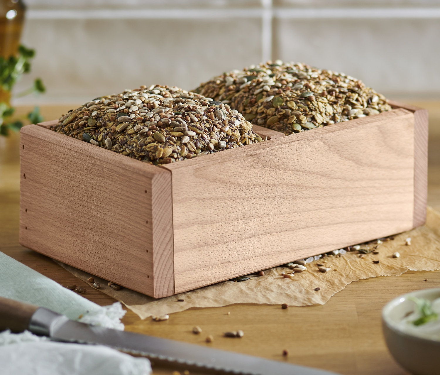 Zwei Brote in einem Holz-Brotbackrahmen.