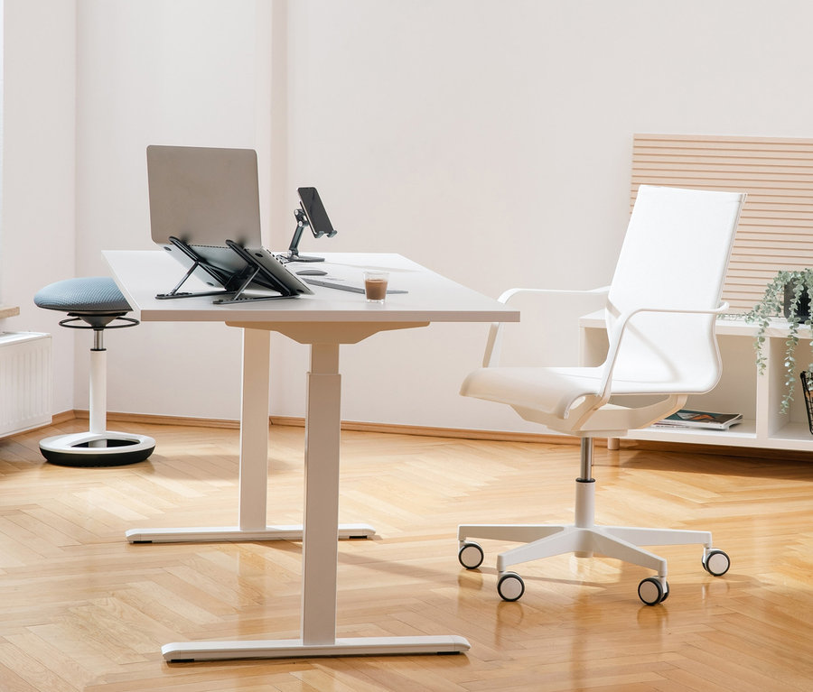 Helles Büro mit höhenverstellbarem Tisch, Laptop, Handy und Kaffee. Im Hintergrund Topstar Bürostuhl »SITNESS Life 40«, weiß und ein weißes Regal.