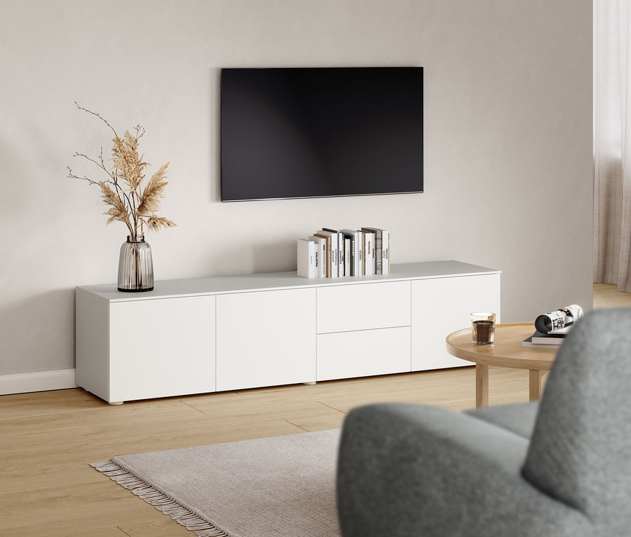 Wohnzimmer mit Lowboard und rundem Couchtisch.