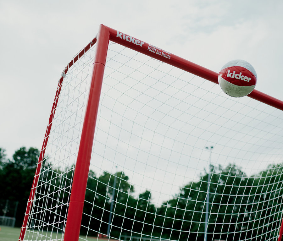 Ein Fußball berührt das rote HUDORA-Fußballtor Expert 300 »kicker-Edition«.