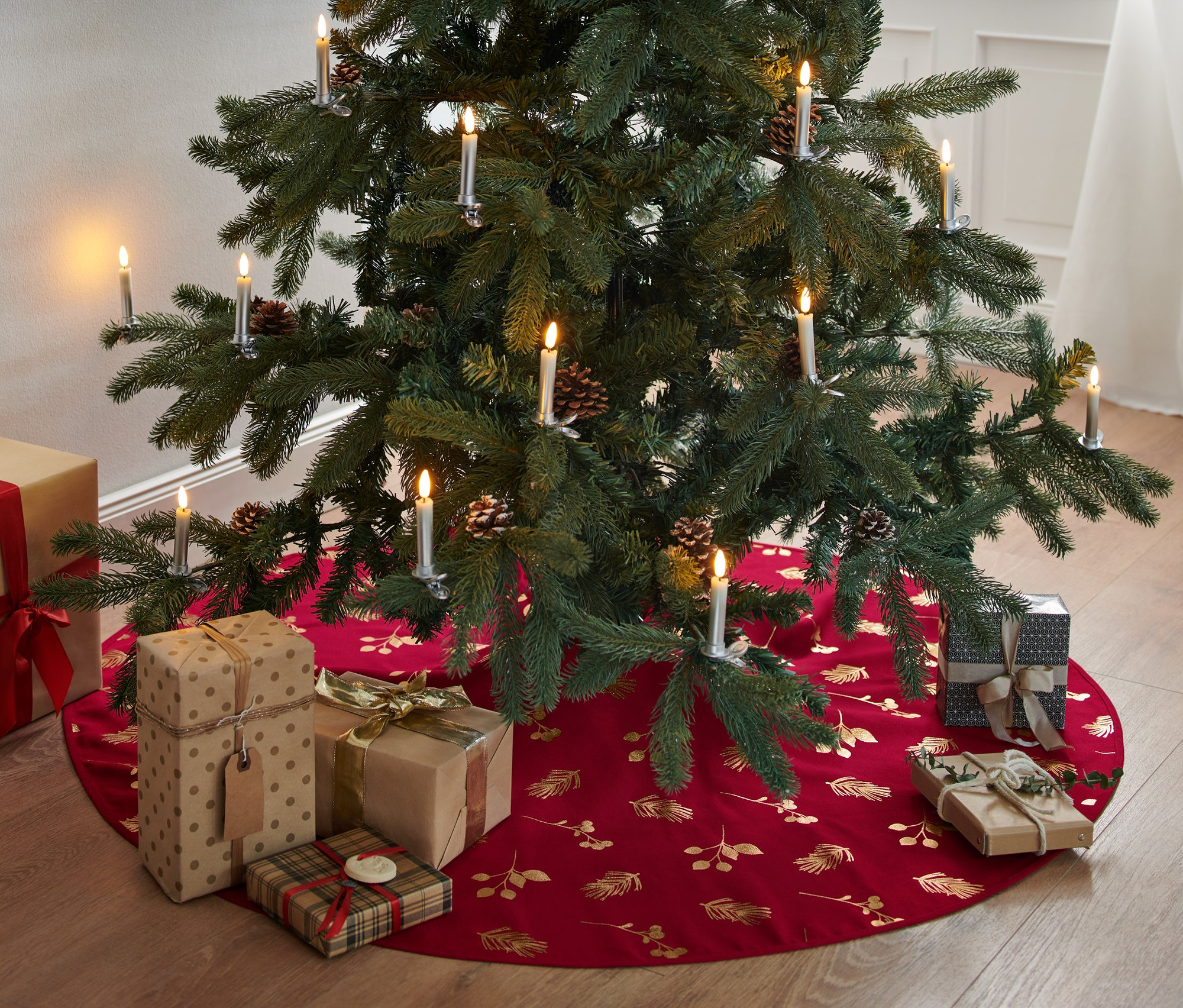 Geschenke liegen unter dem Weihnachtsbaum auf der Tannenbaumdecke.