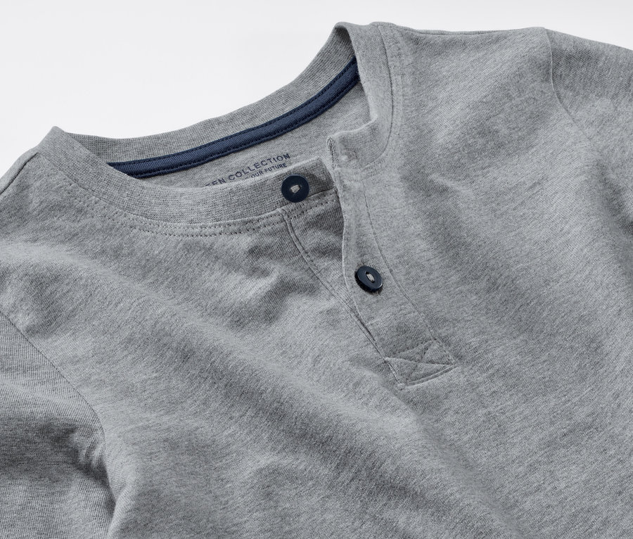 Detailaufnahme eines grauen Kinder-Pyjamas mit dunkelblauen Knöpfen.