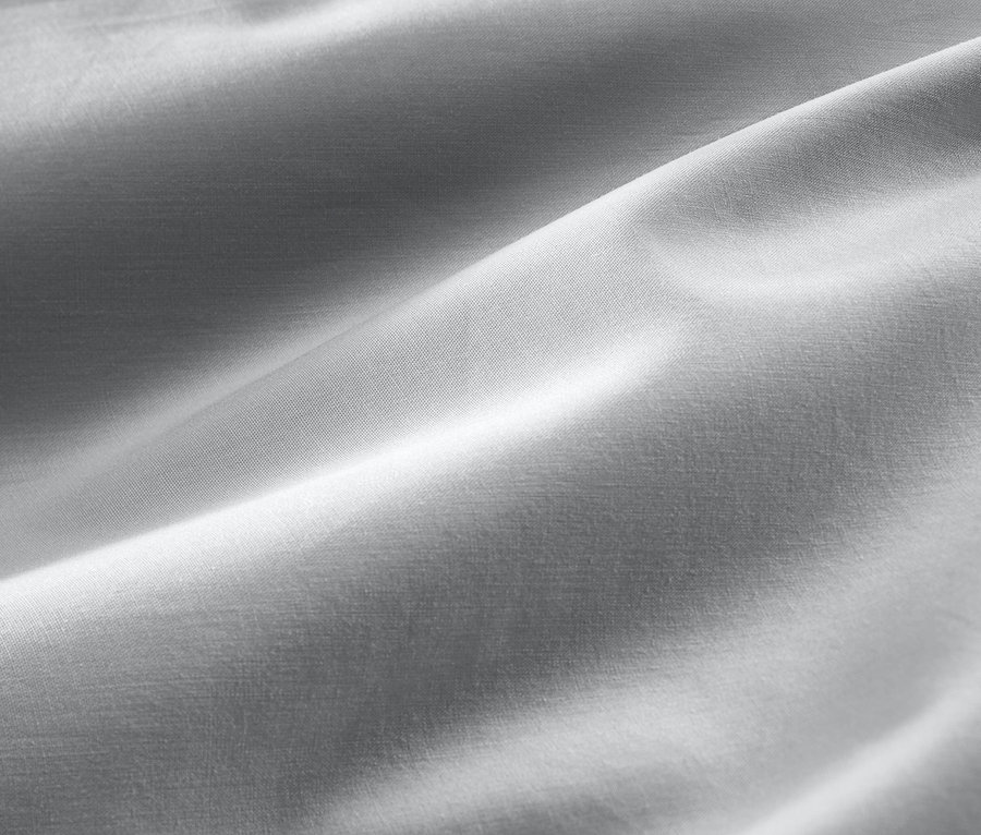 Detailaufnahme von grauer Baumwollsatin-Bettwäsche in Normalgröße und Übergröße.