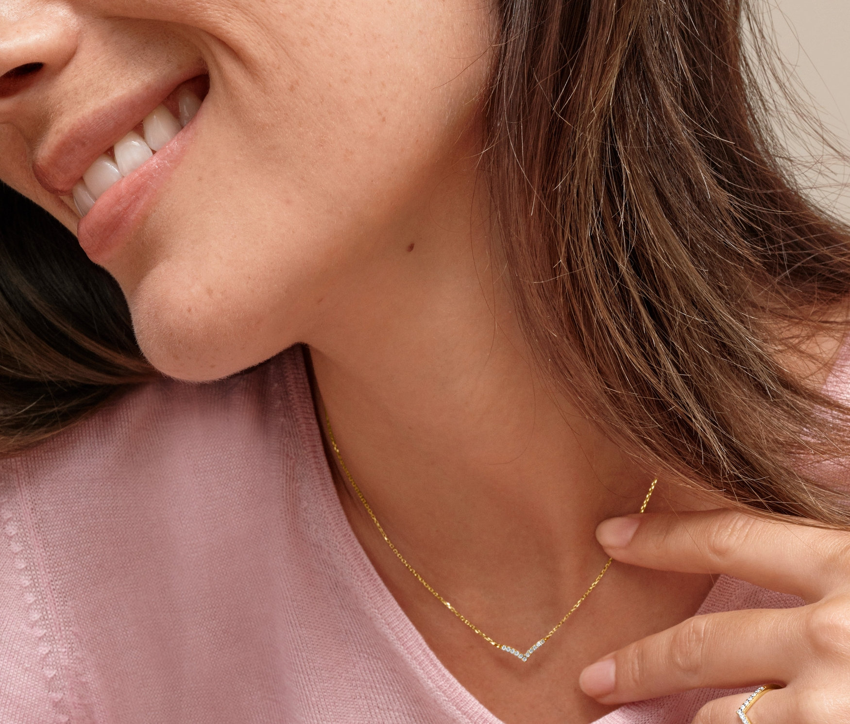 Frau mit Gold-Kette V-Anhänger Zirkonia und Gold Ring V Zirkonia.