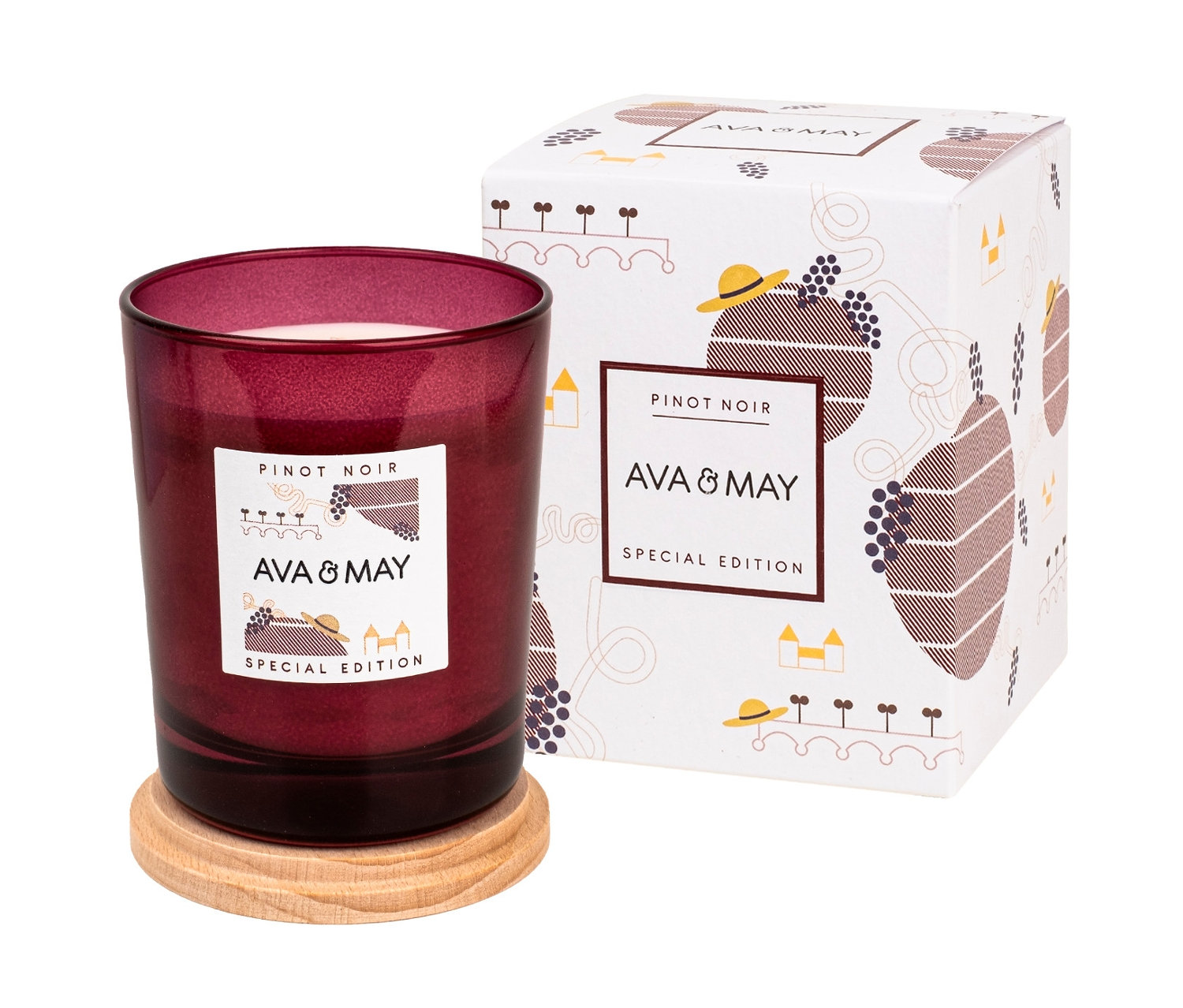 Eine Glasduftkerze »Pinot Noir« von Ava & May auf einem Holzsockel neben einer dekorativen Schachtel.