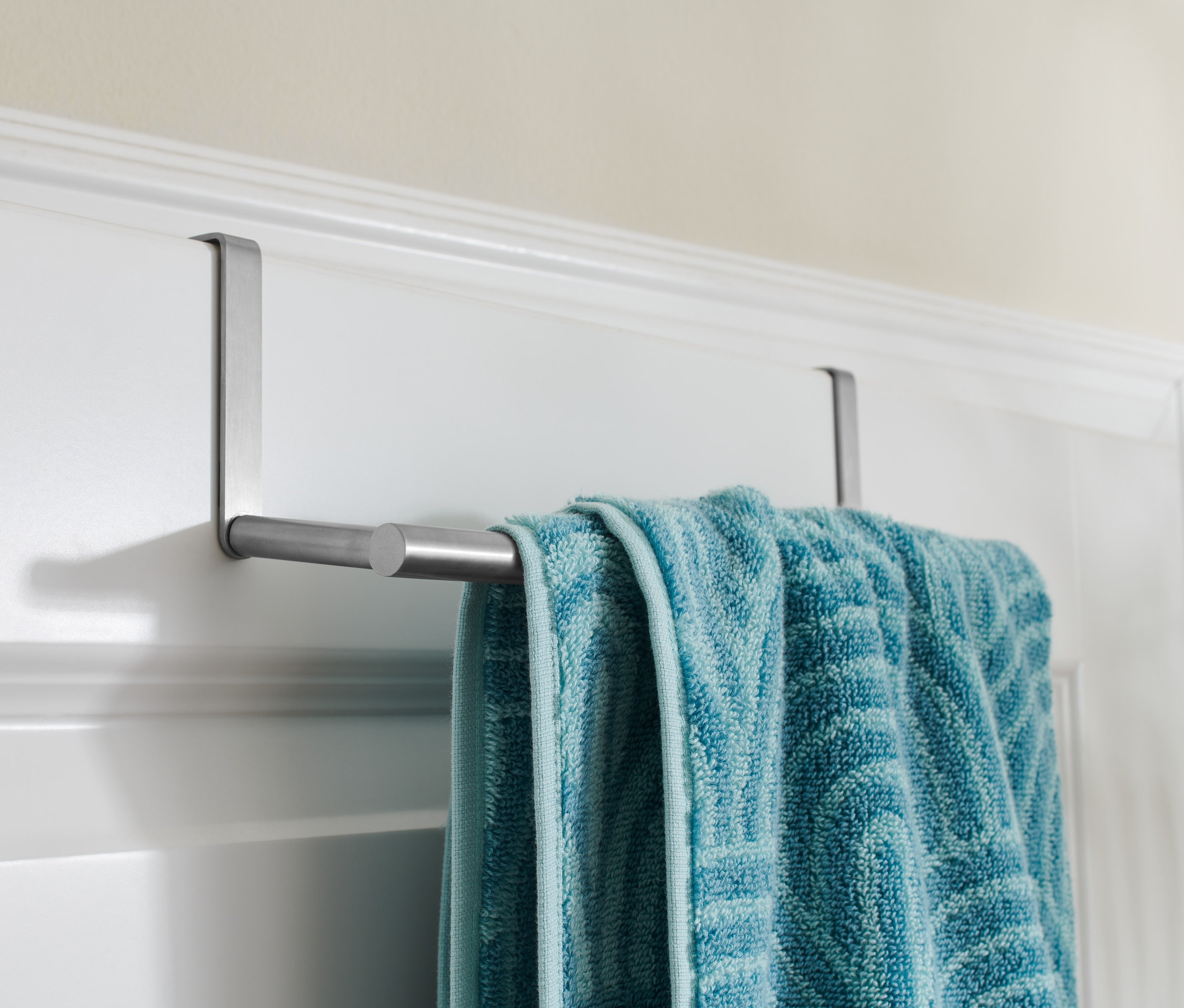 Ein blaues Handtuch hängt an einem Tür-Handtuchhalter.
