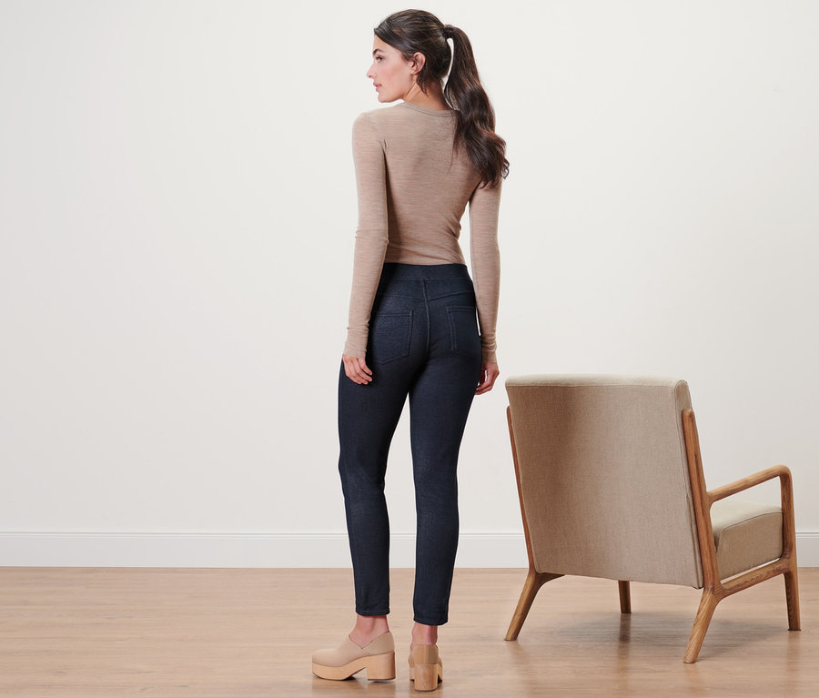 Frau steht mit dem Rücken zur Kamera und trägt eine gefütterte Leggings in Jeansoptik.