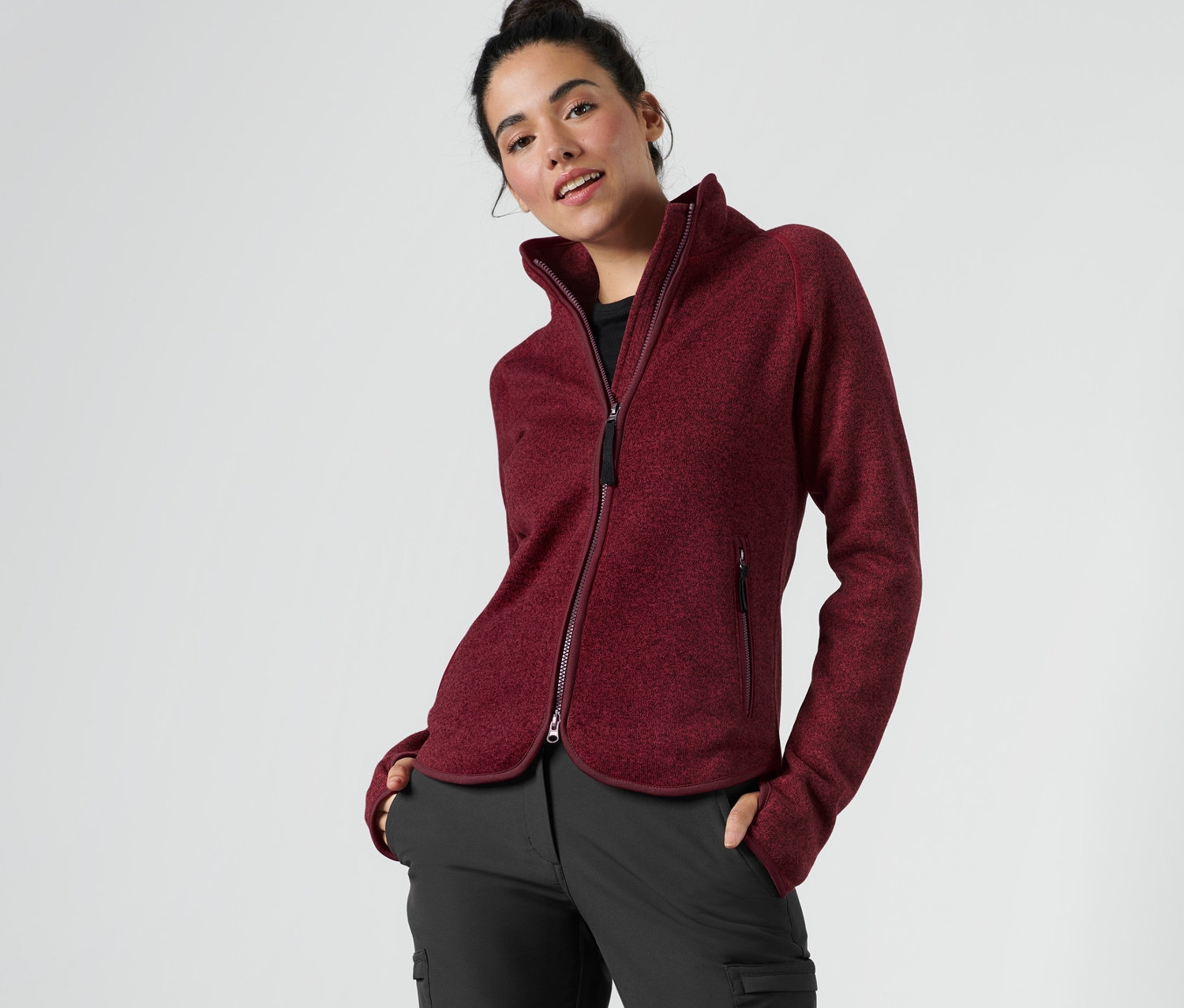 Frau posiert in dunkelroter Strickfleece-Jacke.