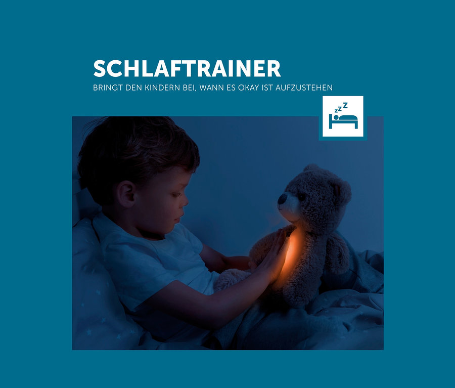 Junge liegt im Bett und schaut auf das leuchtende Zazu Nachtlicht »Brody der Bär«.
