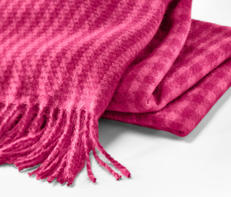 Detailaufnahme eines himbeerfarbenen Webschals mit Fransen.