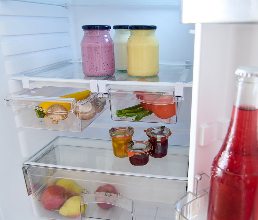 Im Kühlschrank stehen drei Gläser mit Deckel, zwei davon gefüllt und eines leer. Außerdem sind dort 2 ausziehbare Kühlschrankkörbe, einer mit Tomaten und einer mit Champignons und Zucchini.