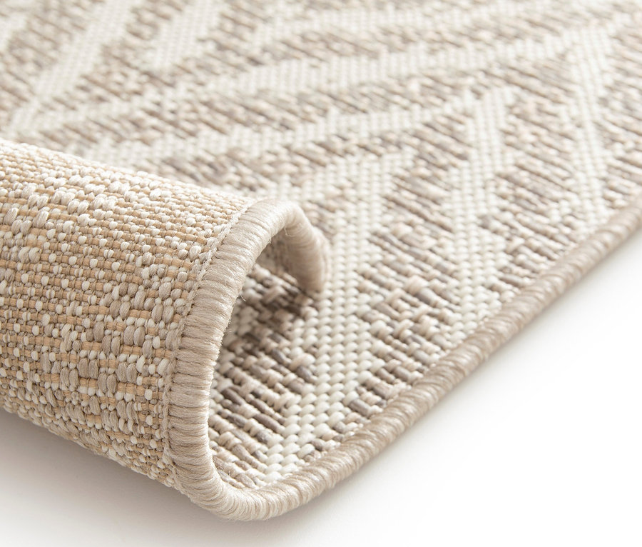 Detailansicht eines beigen Outdoor-Teppichs »Ecru Flow« mit geometrischem Muster.