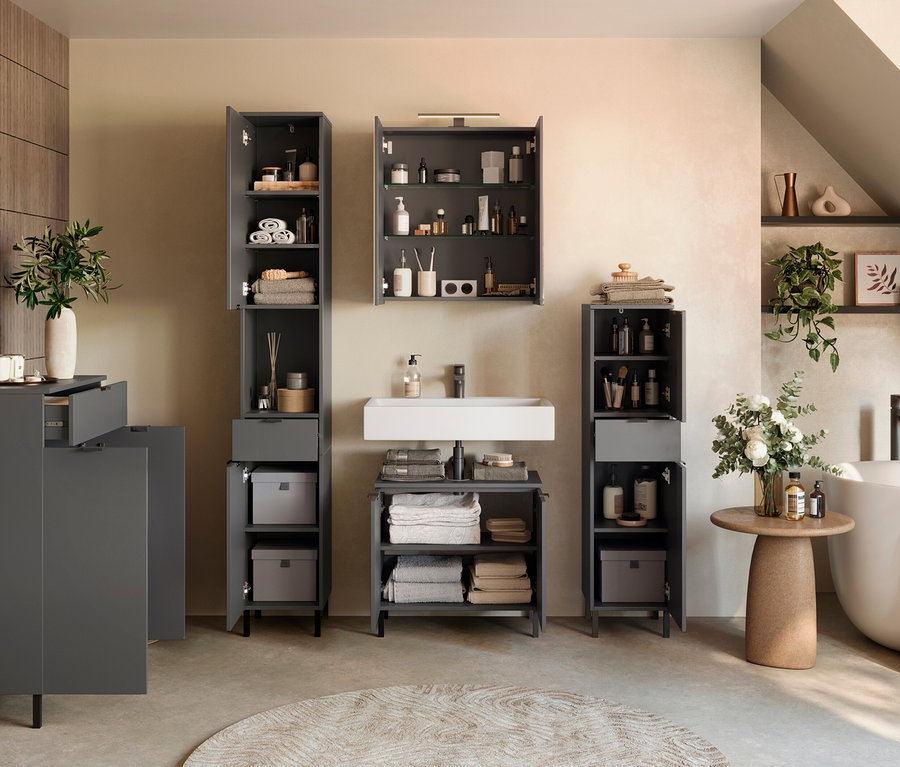 Badezimmer mit grauen Möbeln, inklusive Schränken und Waschbecken, sowie Accessoires wie Handtüchern und Pflanzen.