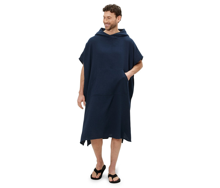 Mann trägt einen Musselin-Umzieh-Poncho und Flip-Flops.