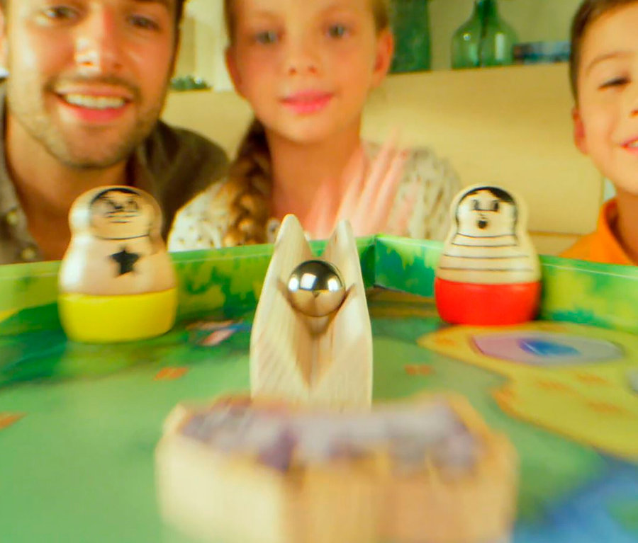 Ein Mann und zwei Kinder spielen das Spiel »Beppo«.