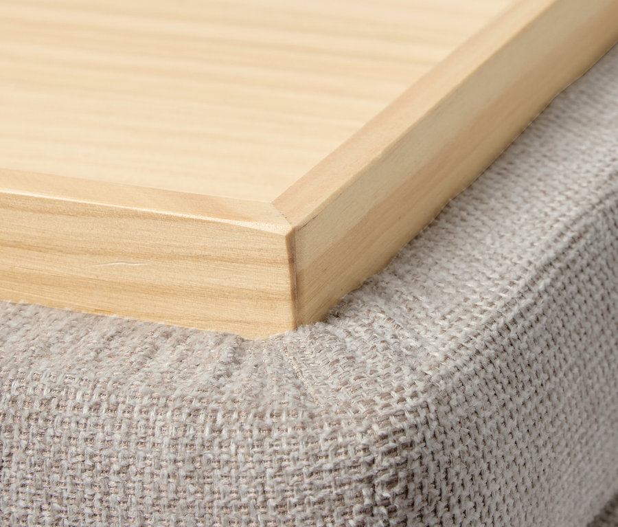 Detailaufnahme eines Holztabletts auf einem grauen Pouf. Pouf mit Rollen und Tablett