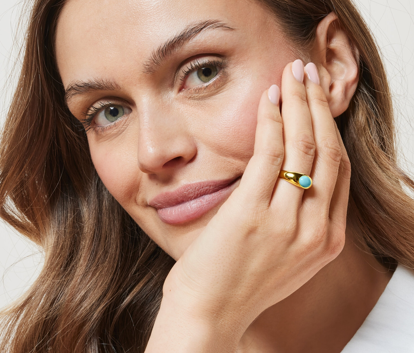 Frau mit goldenem Bandring mit türkisfarbenem Stein.