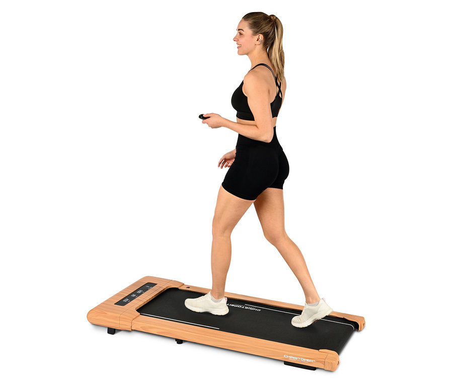 Frau geht auf Christopeit Walking Pad »4.2« in Holzoptik mit Fernbedienung.