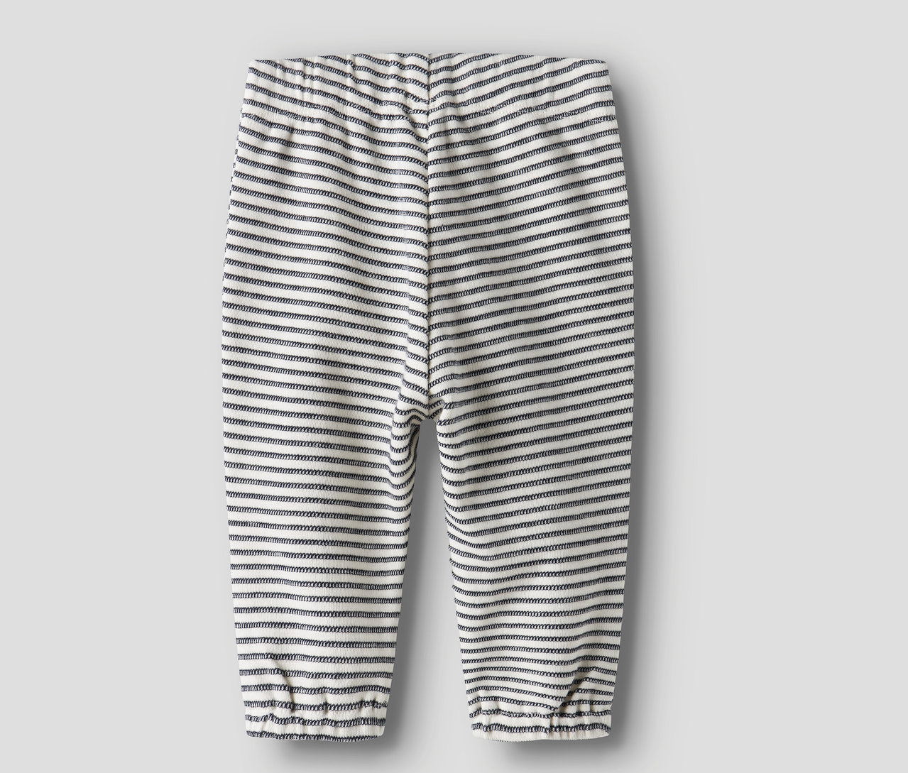 Die Rückseite einer geringelten NAME IT Baby-Jerseyhose ist vor einem grauen Hintergrund zu sehen.