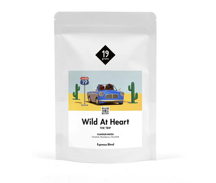 Weiße Verpackung von 19grams Wild at Heart Espresso ganze Bohne mit einer Illustration einer Wüstenlandschaft mit blauem Auto.