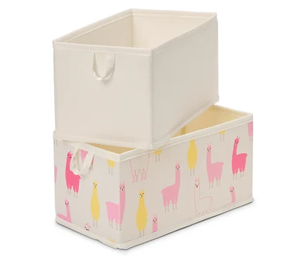 Zwei rechteckige Aufbewahrungsboxen stehen gestapelt übereinander. Die obere Box ist einfarbig beige, die untere Box ist mit rosa und gelben Lamas auf beigem Grund bedruckt.