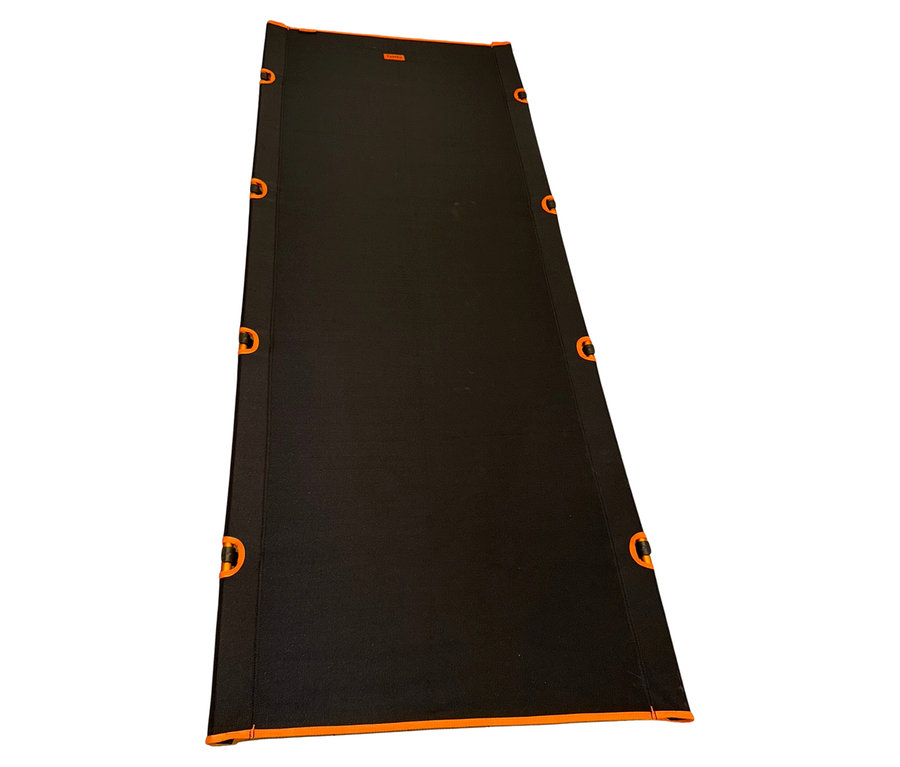 Die schwarze Tambu Camping-Liege »BATIKA« liegt flach und ist mit orangefarbenen Akzenten versehen.