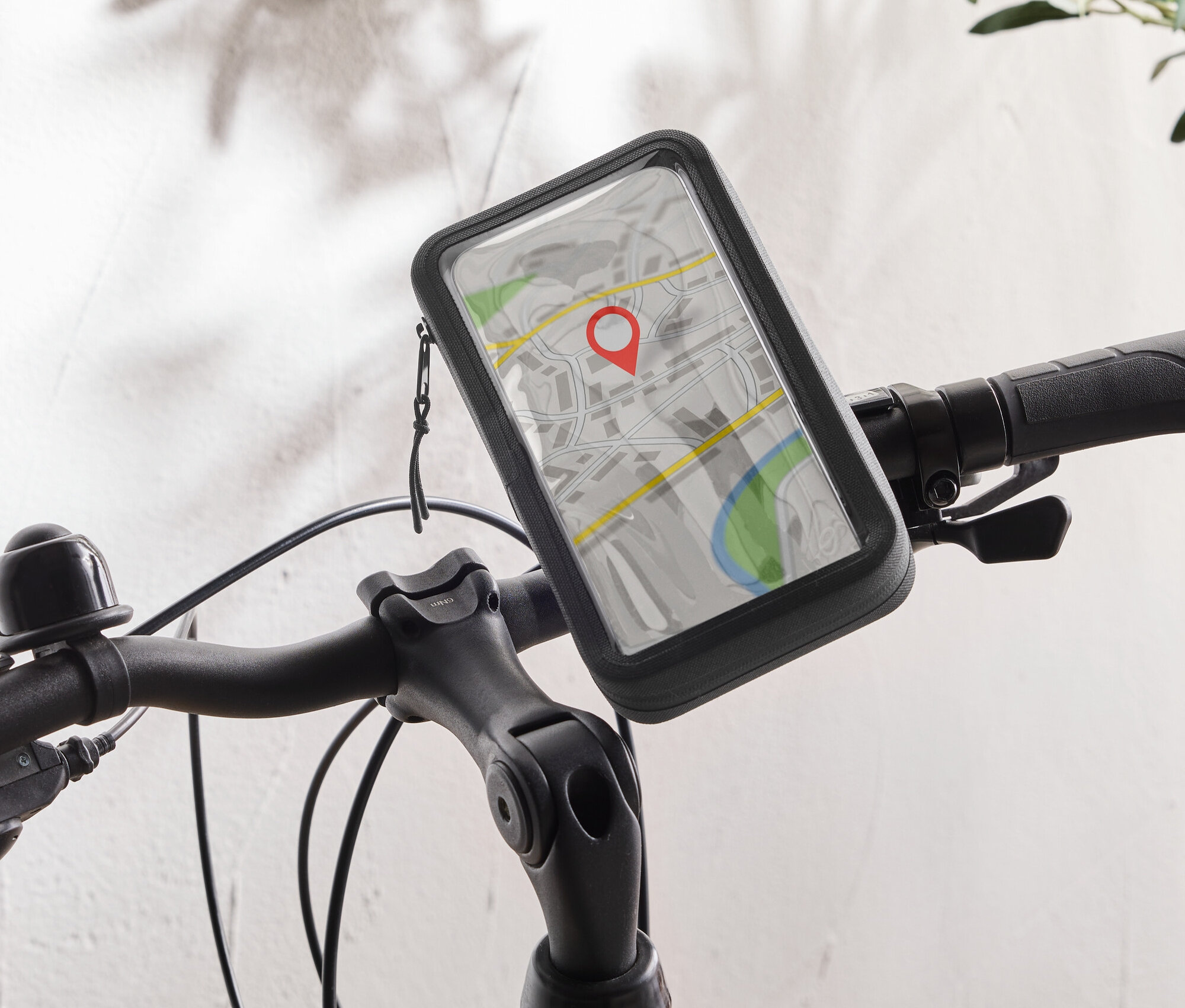 Ein schwarzes Fahrrad mit einer Handyhalterung am Lenker, die eine Karten-App mit einer roten Stecknadel anzeigt.