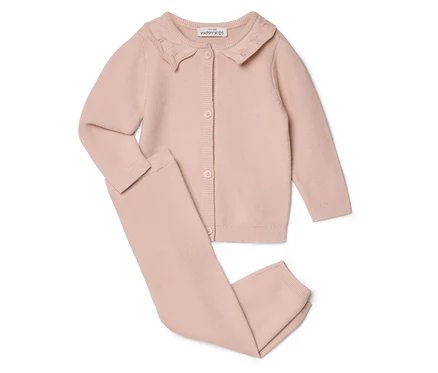 Rosa Strickjacke mit Kragen und Hose liegen auf weißem Grund.