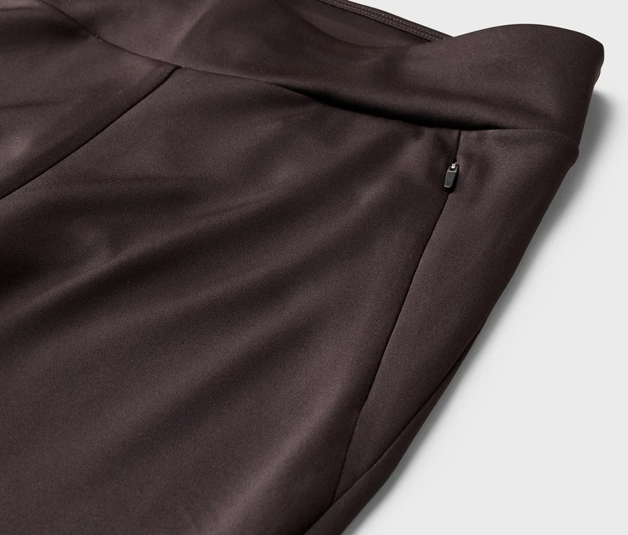 Nahaufnahme einer braunen Hose mit Reißverschlusstasche am Bund.