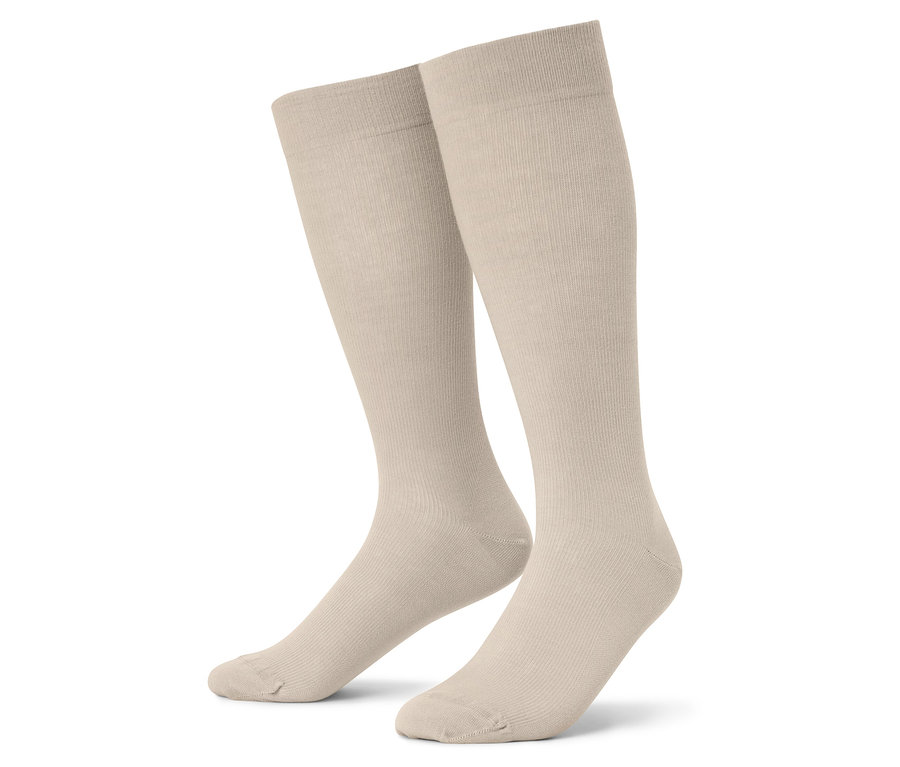 Nahaufnahme von zwei beigen Kniestrümpfen vor einem weißen Hintergrund.